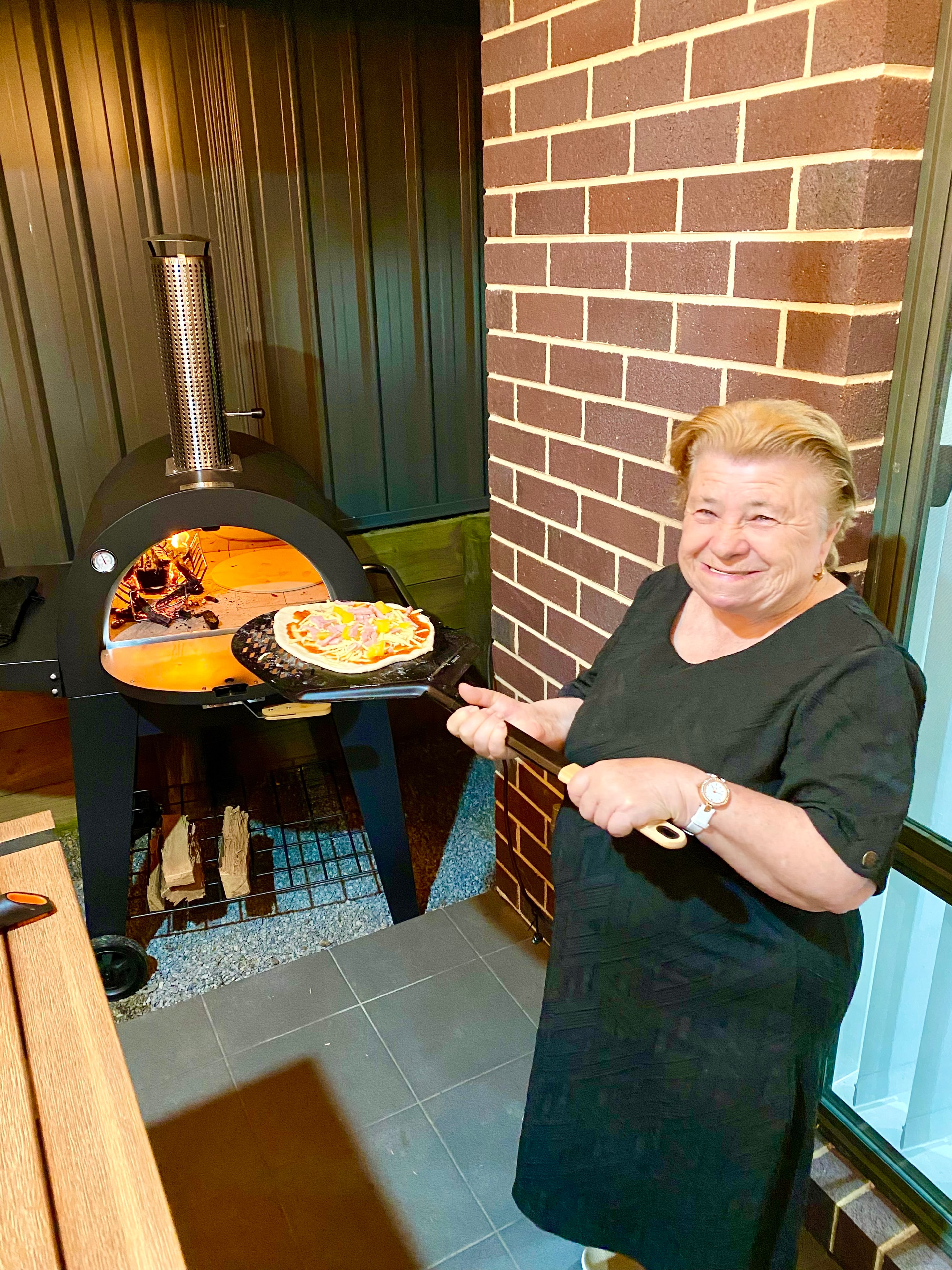 Pure Living participant making pizza in outdoor pizza oven