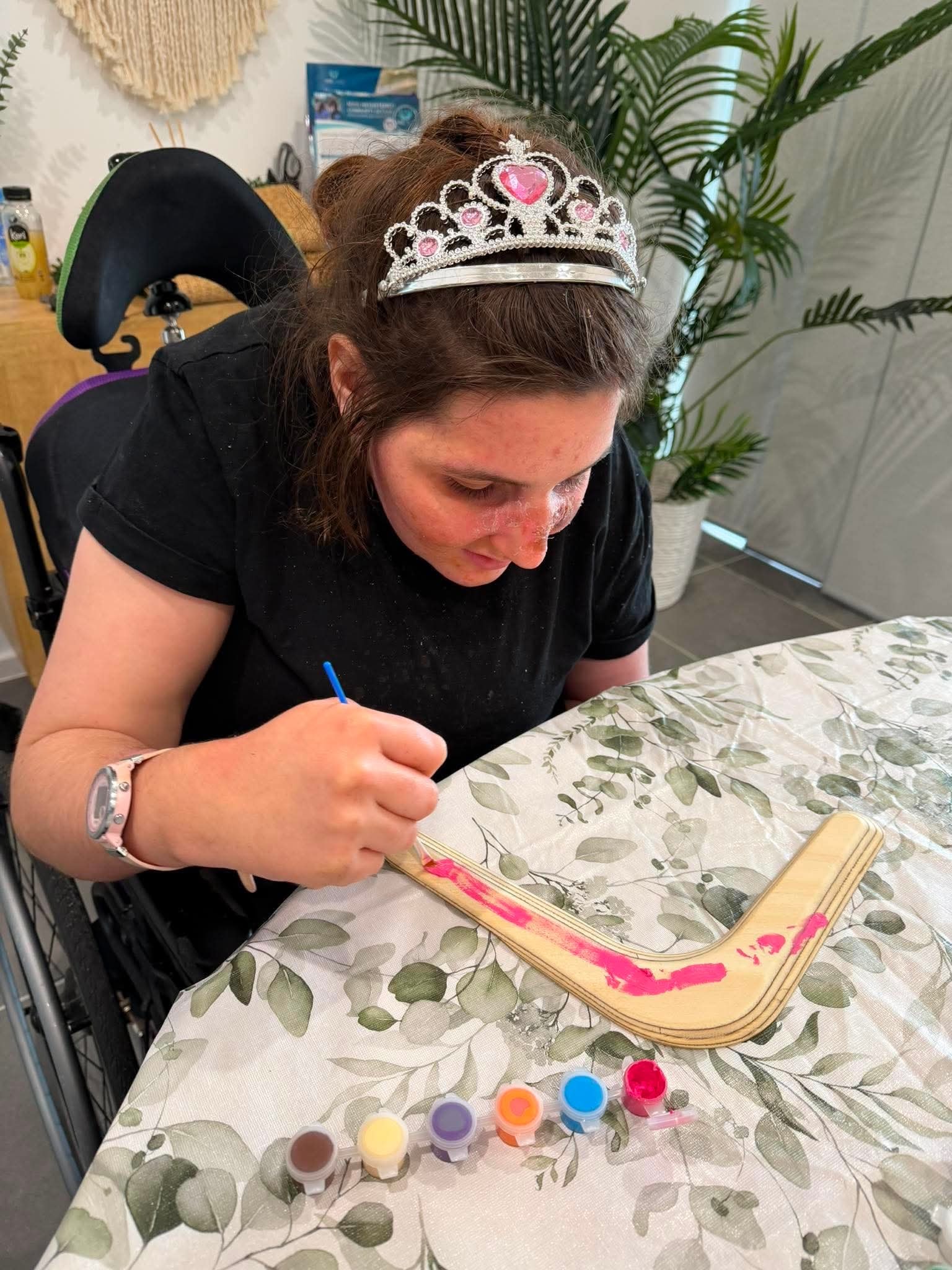 Participant painting a boomerang at the Skills Hub creative arts program